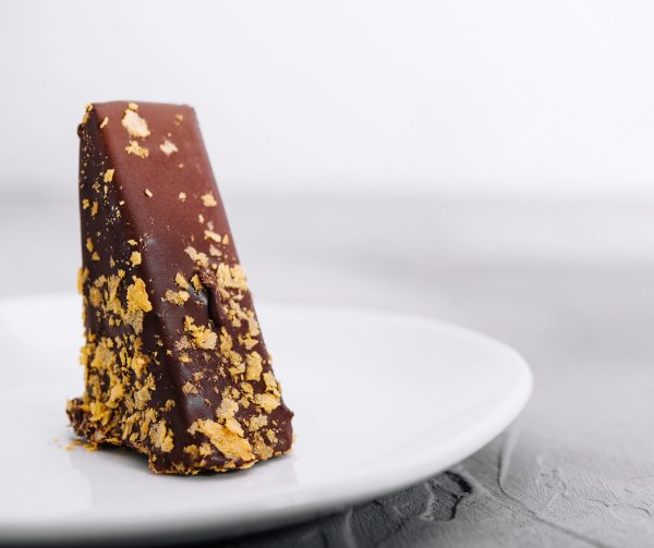 Waffle cake in chocolate glaze on white plate Ouro comestível 24K para finalização de pratos e cocktails